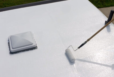 Rolling RV Roof Magic's roof coating near a skylight.